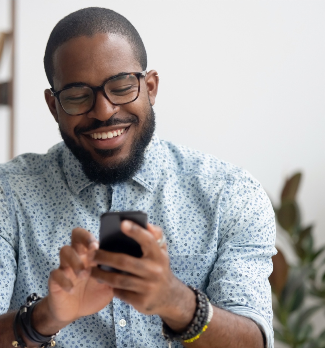 man smiles while checking phone