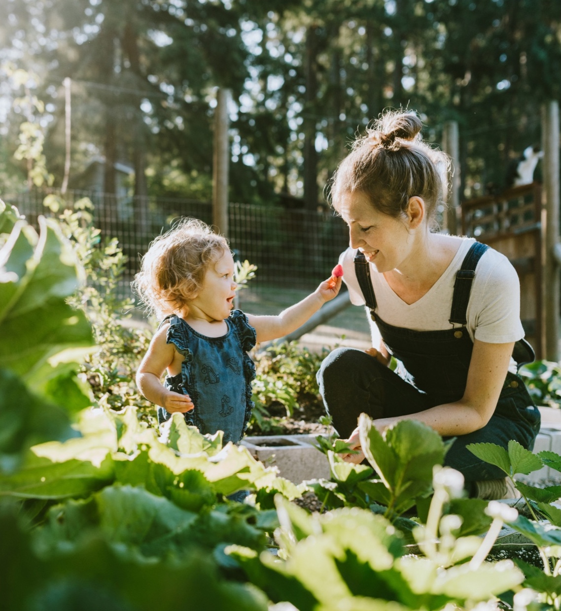 a mother helps her child garden