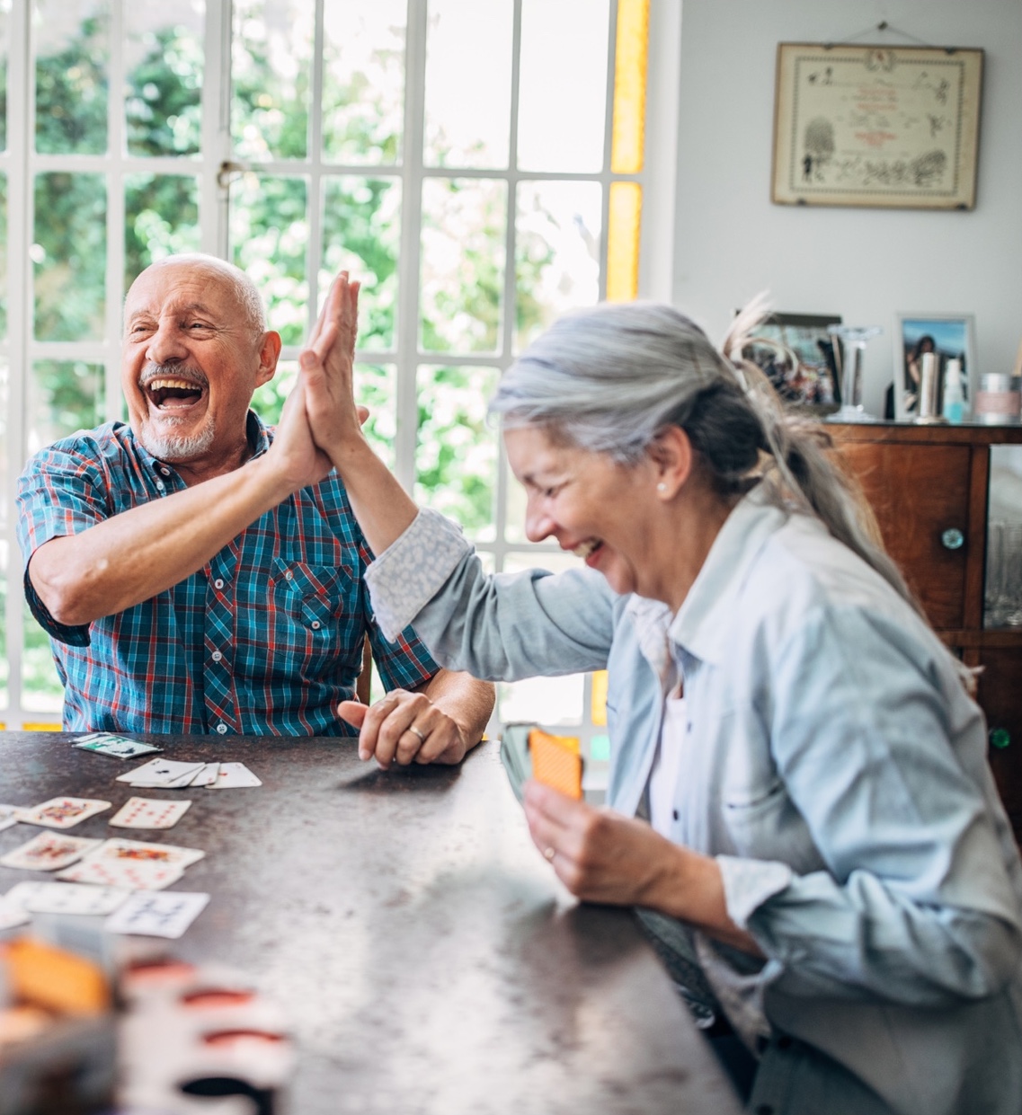 A man and woman laughing over a card game