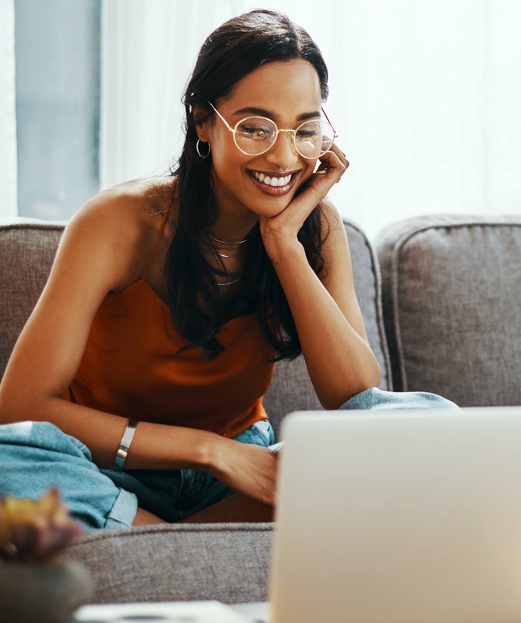 Shot of a young woman using a laptop on the sofa at home